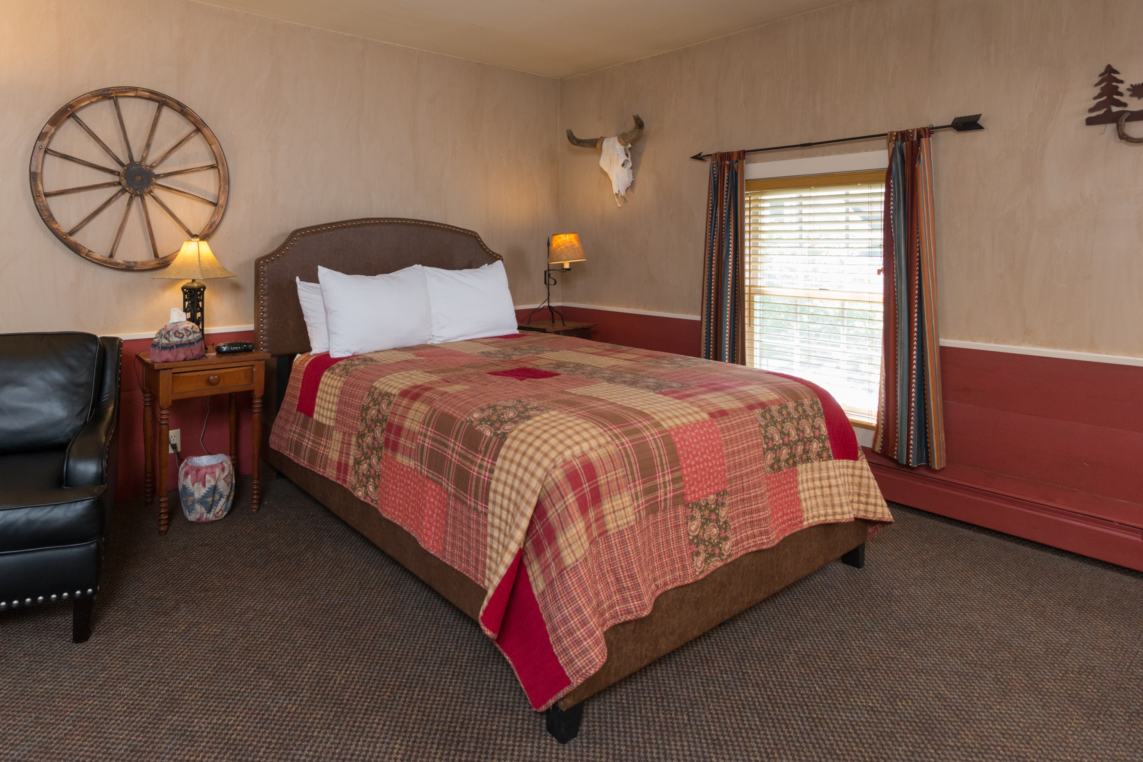 Patchwork quilted bed with wagon wheel decoration on wall