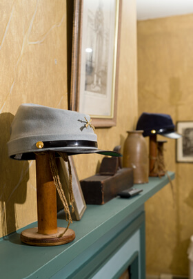 Civil war hat and knickknacks on fireplace mantel