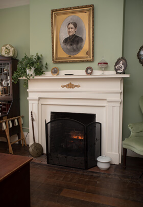 white mantel fireplace with woman's portrait on wall