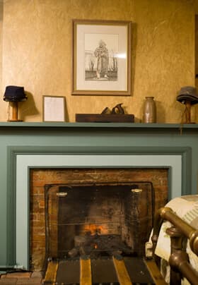 Green facade fireplace with knickknacks on mantel