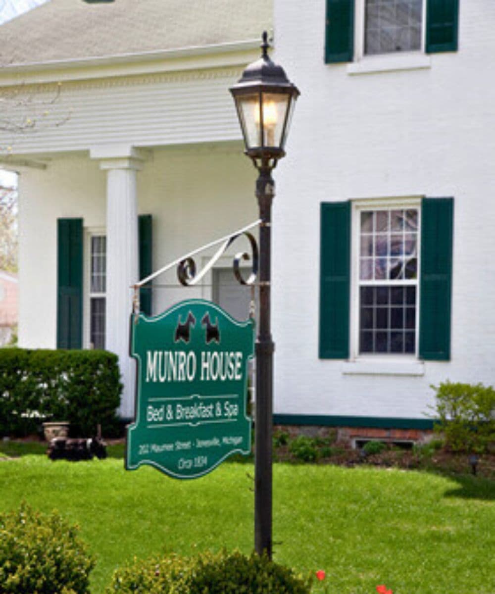 Sign for Munro House Bed & Breakfast & Spa in front of a white building with green shutters.
