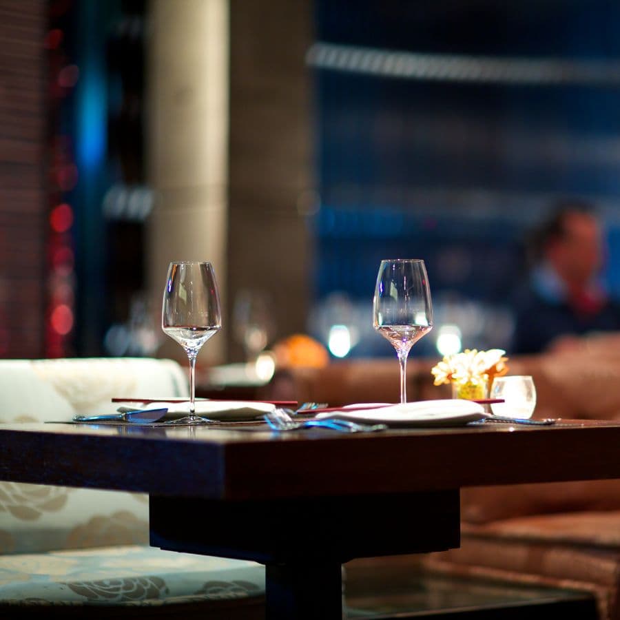 A beautifully set dining table with wine glasses in a cozy restaurant ambiance.