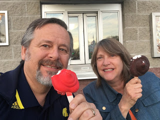 White couple eating ice cream on a stick one cherry and one chocolate