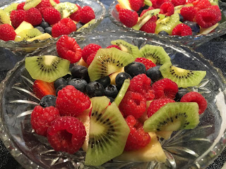 Fresh fruit bowl with red raspberries blueberries pineapple green kiwi