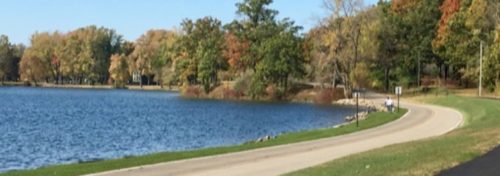 Blue lake green grass mulitcolored leaves on trees